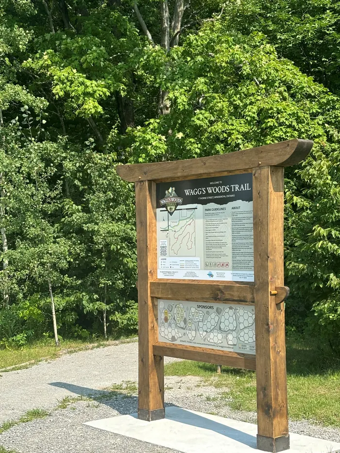 The timber-framed Wagg's Woods trailhead sign beside the parking area